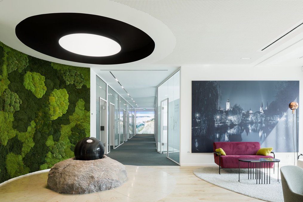 Eingangsbereich mit Pflanzwand, Wasserspiel und Glastrennwänden