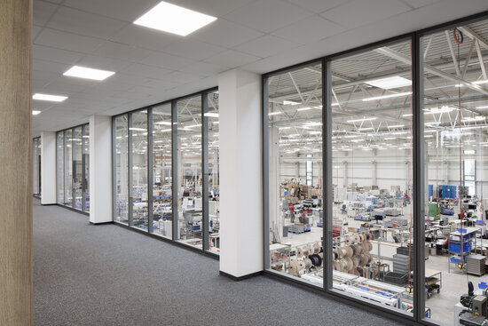 Projekt BST Blick durch Glastrennwandsysteme auf Produktionshalle