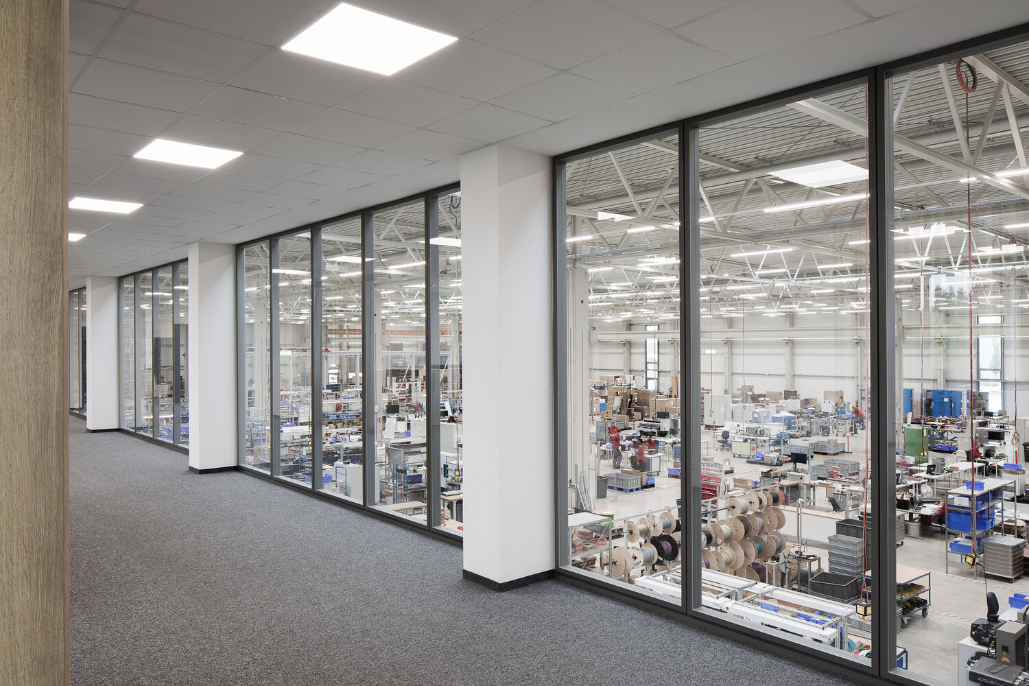 Projekt BST Blick durch Glastrennwandsysteme auf Produktionshalle