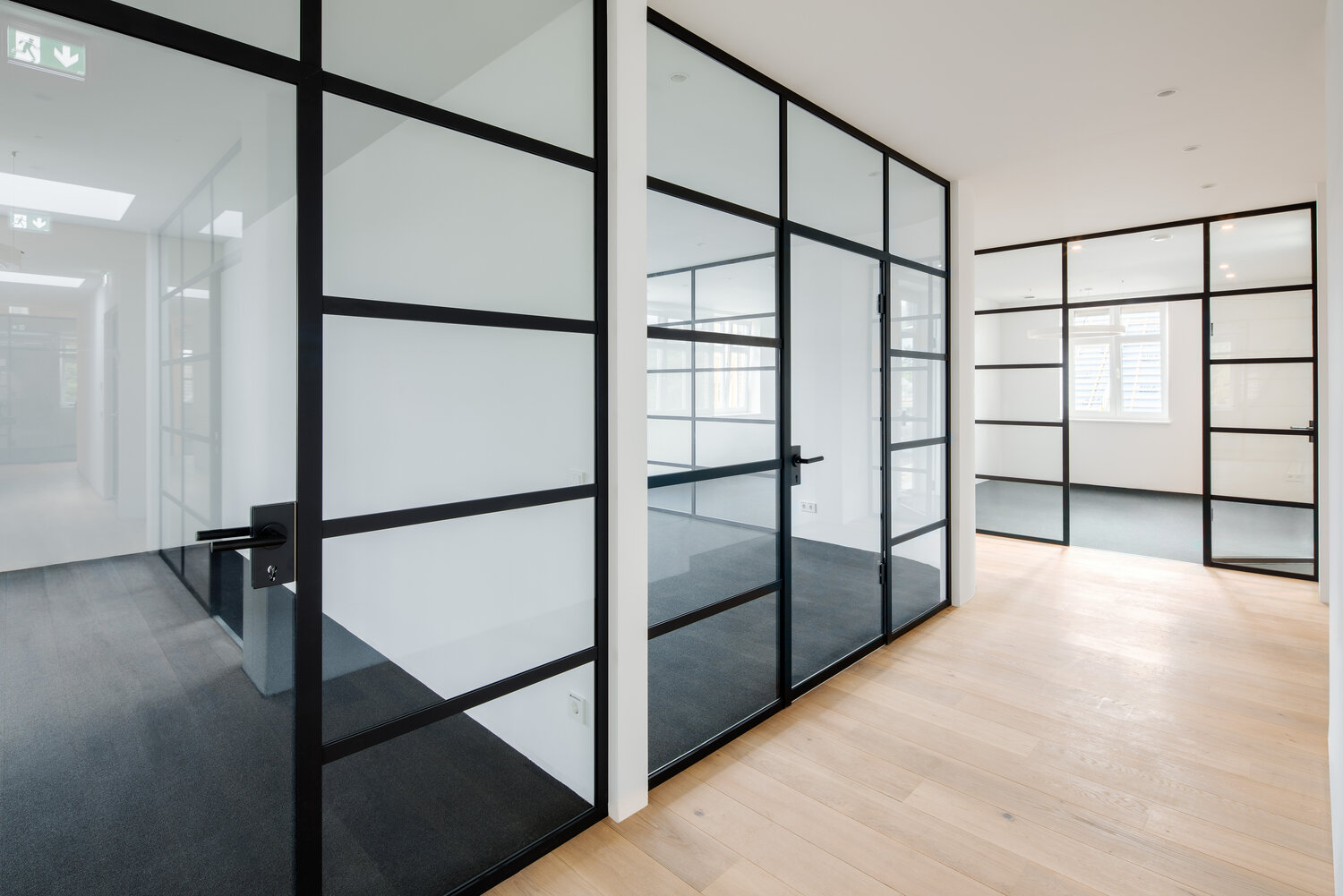 Projekt Heigel Glastrennwände mit schwarzen Leisten industrial look
