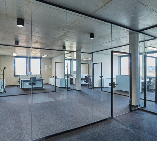 Projekt Geiger Blick durch Glaswand in Büro mit rahmenlosen Glastrennwandsystemen